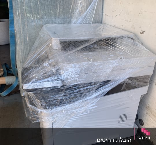 מדפסת עטופה בניילון בתוך משאית הובלה